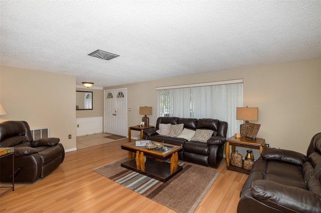 living room with light hardwood / wood-style floors and a textured ceiling