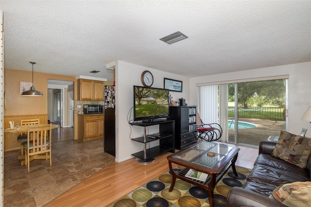 living room with a textured ceiling and hardwood / wood-style flooring