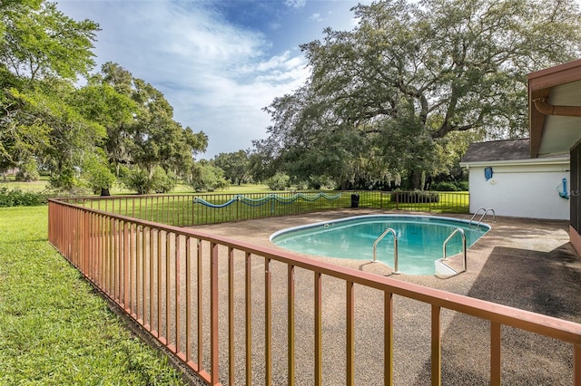 view of swimming pool with a lawn and a patio