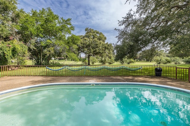 view of pool with a lawn