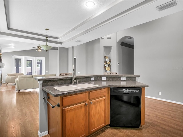 kitchen with a tray ceiling, light hardwood / wood-style flooring, sink, dishwasher, and ceiling fan