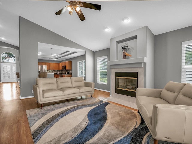 living room featuring plenty of natural light, lofted ceiling, light wood-type flooring, and ceiling fan