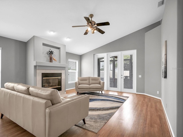 living room featuring lofted ceiling, light wood-type flooring, a wealth of natural light, and ceiling fan