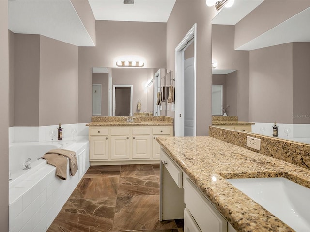 bathroom featuring a relaxing tiled tub, tile patterned floors, and double sink vanity