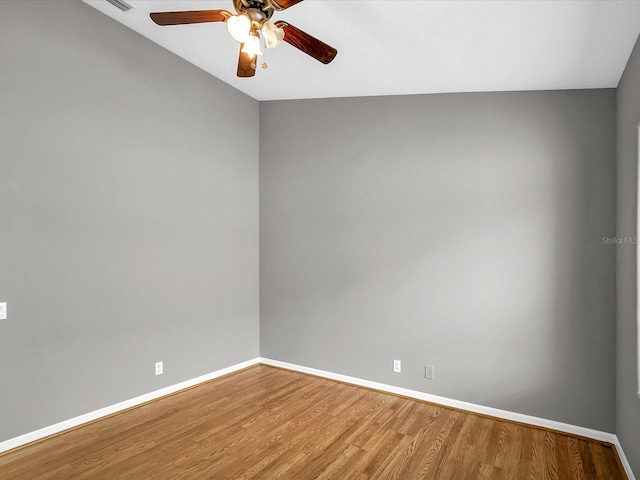 empty room with lofted ceiling, hardwood / wood-style floors, and ceiling fan