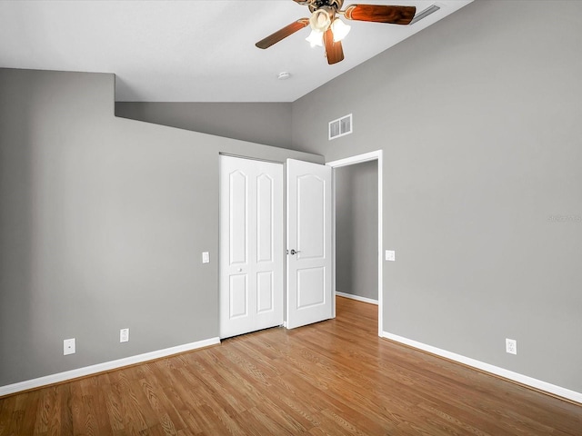 unfurnished bedroom with light hardwood / wood-style flooring, ceiling fan, and high vaulted ceiling