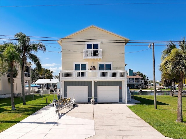 coastal home featuring a garage, a front lawn, a balcony, and a water view