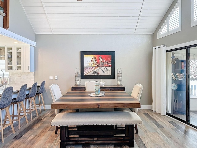 dining area featuring lofted ceiling and light wood-type flooring