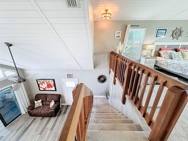 staircase featuring ceiling fan and wood-type flooring