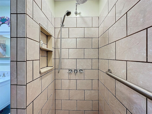 bathroom featuring tiled shower and sink