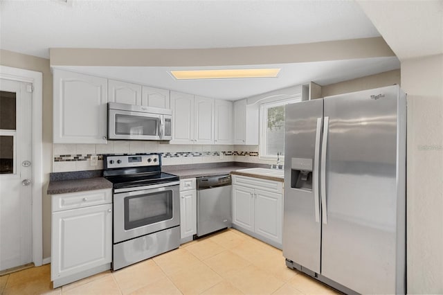 kitchen with white cabinets, appliances with stainless steel finishes, and light tile patterned floors