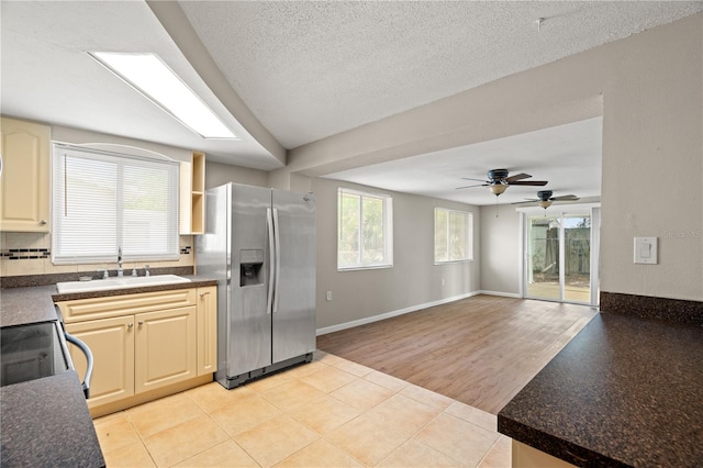 kitchen featuring ceiling fan, sink, stainless steel fridge, a textured ceiling, and light tile patterned flooring