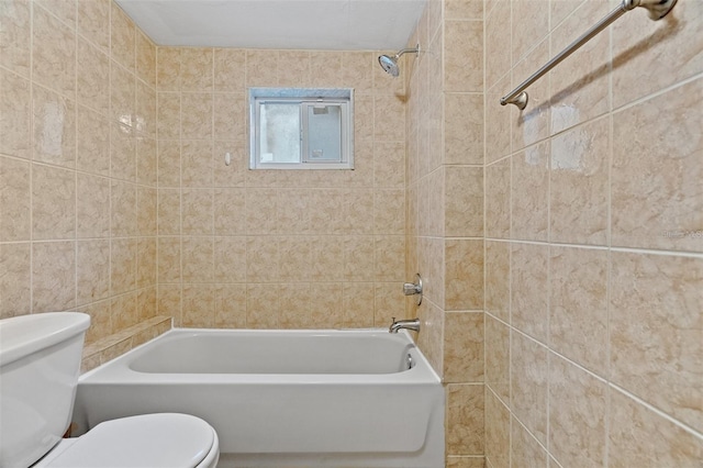 bathroom featuring tiled shower / bath combo and toilet