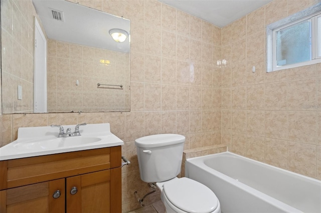 bathroom featuring tile patterned floors, vanity, toilet, and tile walls