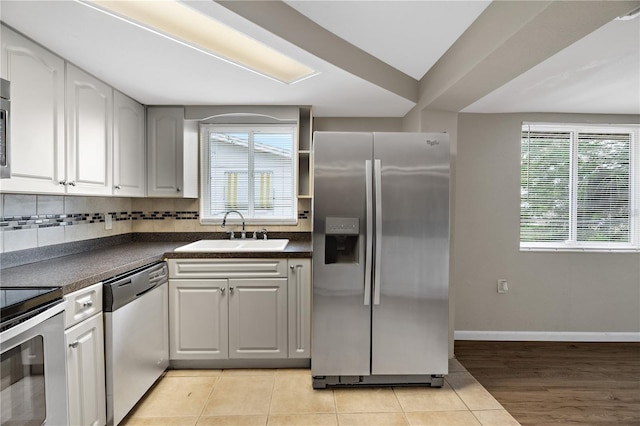 kitchen featuring white cabinets, light tile patterned floors, sink, and appliances with stainless steel finishes