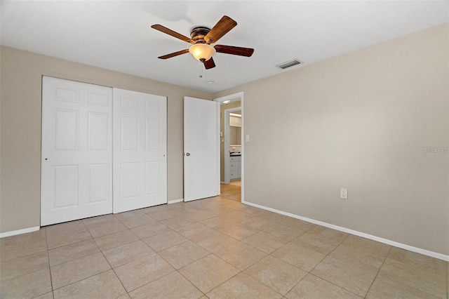 unfurnished bedroom with ceiling fan, a closet, and light tile patterned floors