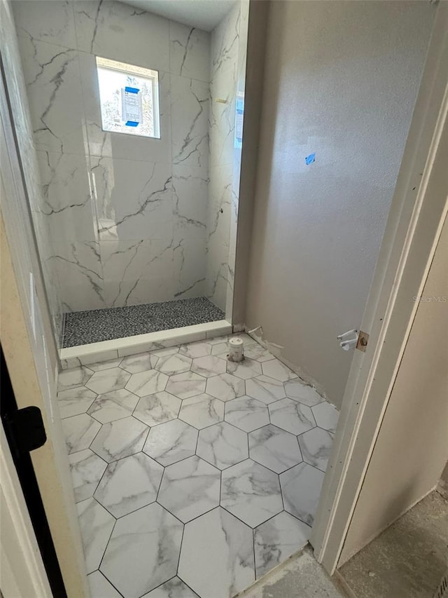 full bath featuring a marble finish shower and marble finish floor