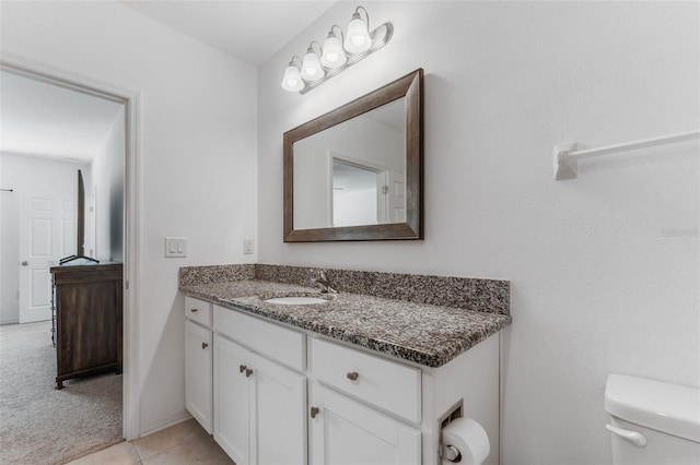 bathroom with tile patterned flooring, vanity, and toilet