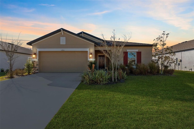 single story home with a garage and a lawn