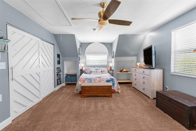 bedroom featuring ceiling fan, lofted ceiling, carpet flooring, and a textured ceiling