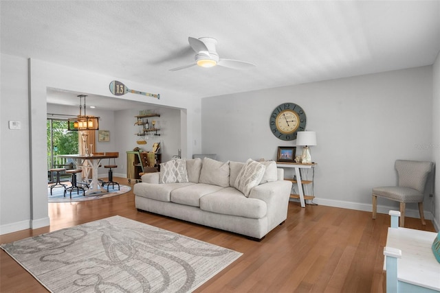 living room featuring wood-type flooring and ceiling fan