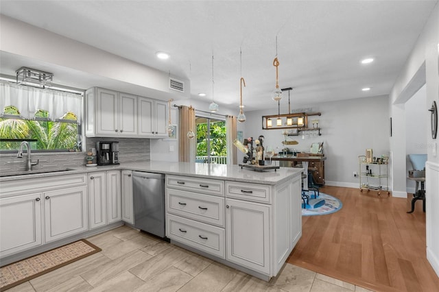 kitchen featuring sink, backsplash, decorative light fixtures, stainless steel dishwasher, and kitchen peninsula