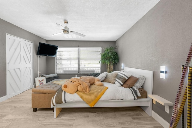 bedroom with a textured ceiling and ceiling fan