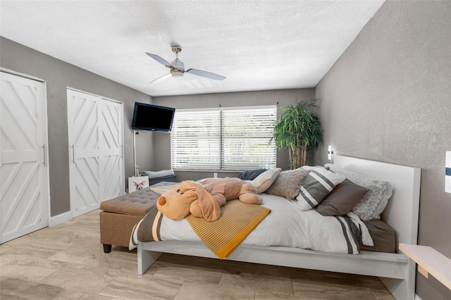 bedroom with ceiling fan and a textured ceiling