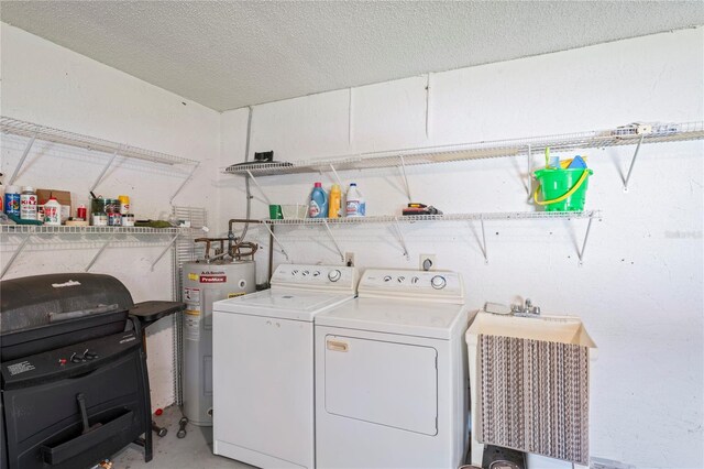 laundry room with water heater, sink, washer and clothes dryer, and a textured ceiling