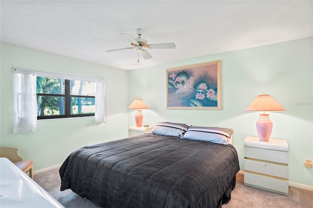 carpeted bedroom with ceiling fan and a textured ceiling