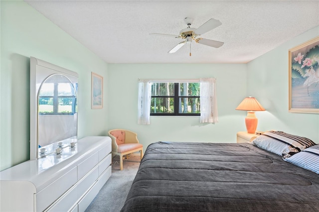 bedroom with carpet, ceiling fan, and a textured ceiling