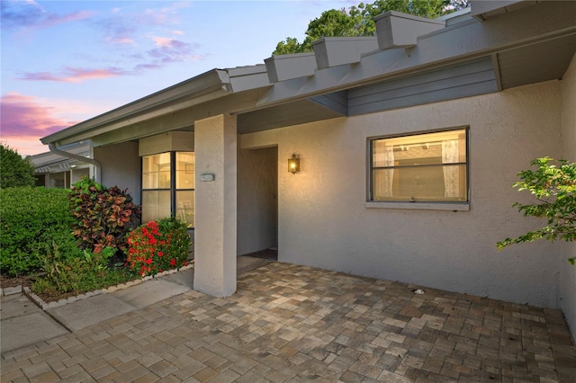 exterior entry at dusk featuring a patio