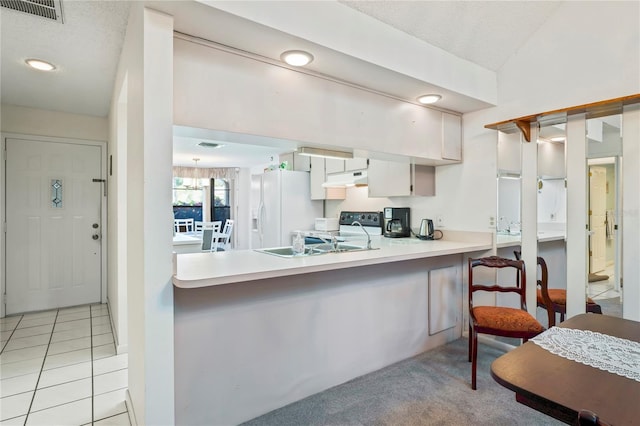 kitchen featuring sink, a breakfast bar area, kitchen peninsula, white fridge with ice dispenser, and white cabinets