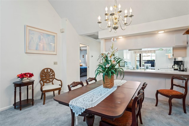 carpeted dining area with lofted ceiling and a chandelier