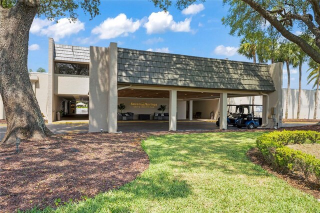 back of house with a carport and a yard