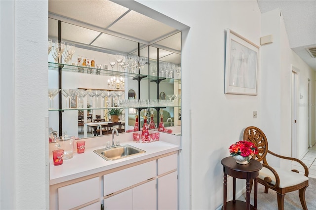 bar featuring white cabinetry and sink