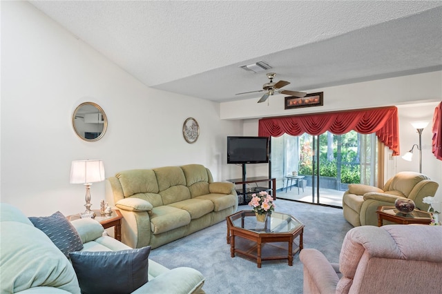 living room featuring ceiling fan, vaulted ceiling, carpet flooring, and a textured ceiling