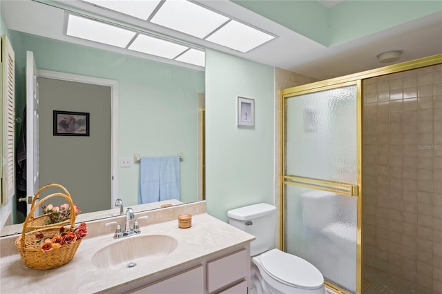 bathroom with an enclosed shower, vanity, a skylight, and toilet