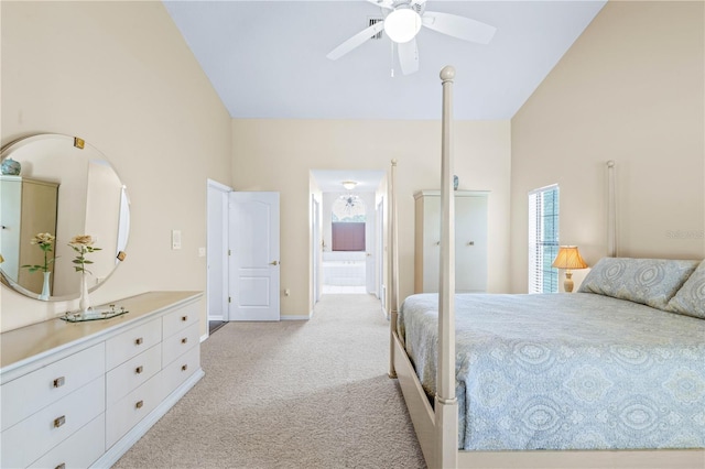 bedroom with ceiling fan, ensuite bathroom, high vaulted ceiling, and light colored carpet