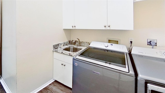 laundry room with dark hardwood / wood-style flooring, cabinets, independent washer and dryer, and sink