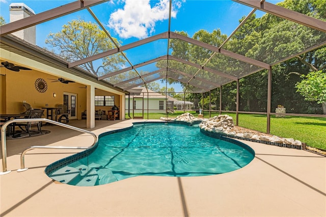 view of swimming pool featuring ceiling fan, a yard, french doors, a lanai, and a patio area