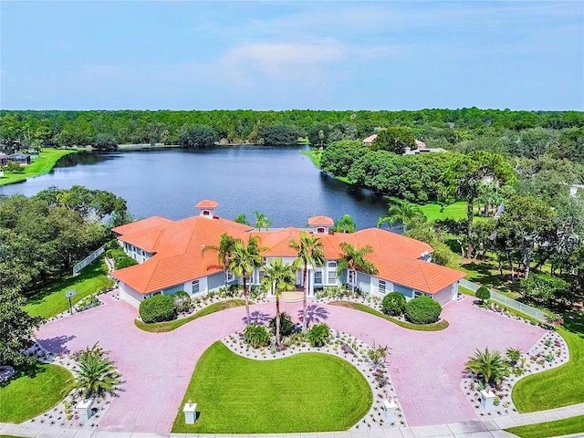 birds eye view of property with a water view and a wooded view