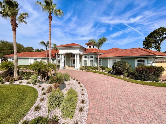 mediterranean / spanish-style home with decorative driveway and stucco siding