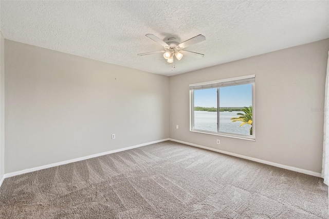 empty room featuring a textured ceiling, ceiling fan, and carpet flooring