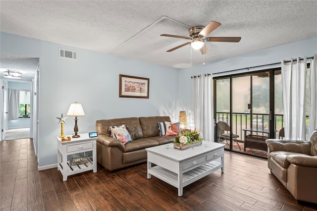 living room featuring ceiling fan, dark hardwood / wood-style flooring, and a textured ceiling