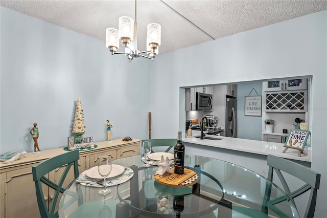 dining area featuring sink, a textured ceiling, and an inviting chandelier