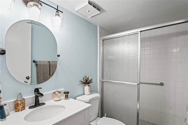 bathroom featuring vanity, toilet, and a shower with shower door