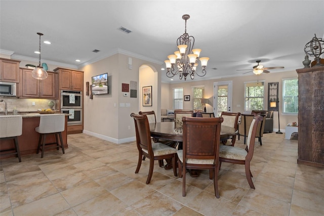 dining room with sink, ceiling fan with notable chandelier, and ornamental molding