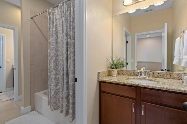 bathroom with tile patterned floors, shower / bath combo with shower curtain, and vanity