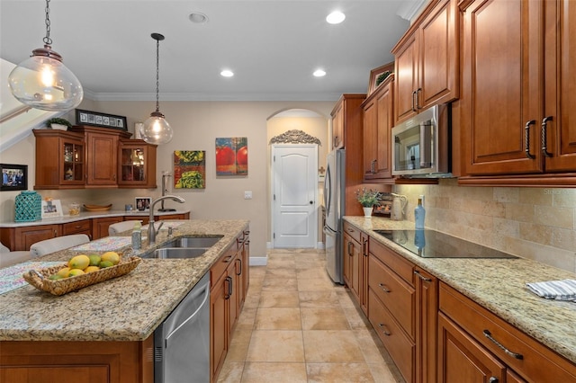 kitchen with a center island with sink, pendant lighting, sink, and appliances with stainless steel finishes